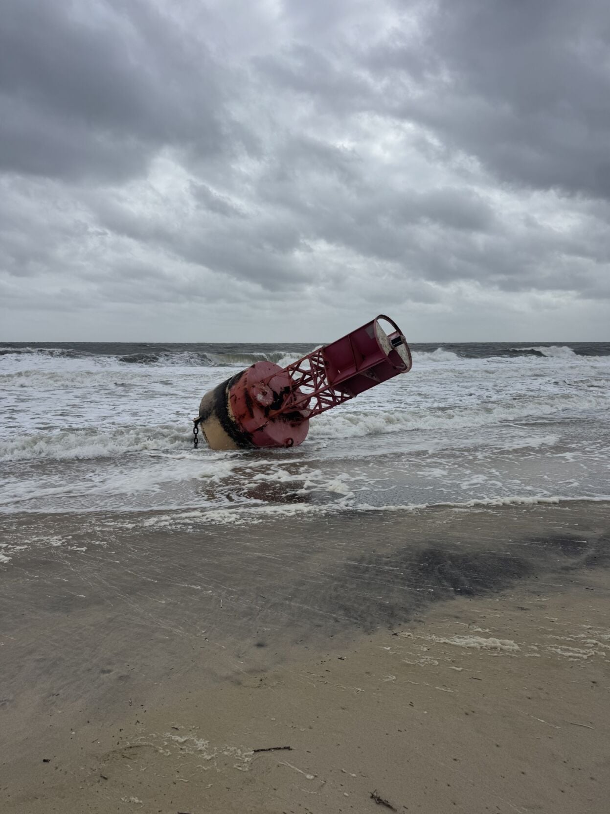 A red buoy washed up on the beach.
