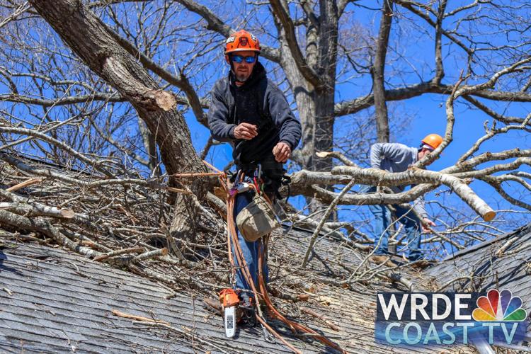 A volunteer removing debris from a roof.