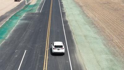 A car driving down the newly paved and reopened Round Pole Bridge Road in Milton