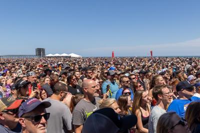 A large crowd of festival goers on the beach.
