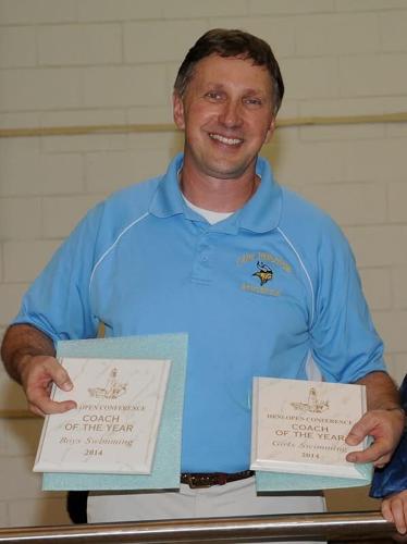 Geppert holds two award plaques, wearing a blue Cape Henlopen polo.