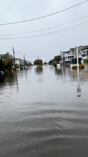 Kayakers float down a flooded street.