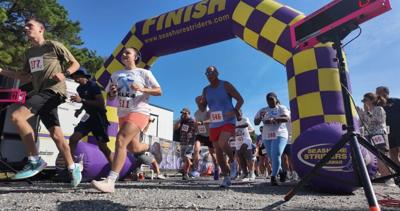 People running through the finish line at Cape Henlopen State Park.