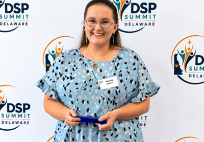 the recipient poses with her award 