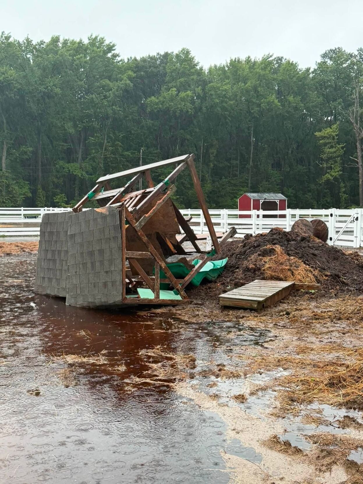 An enclosure for farm animals destroyed, on the ground.