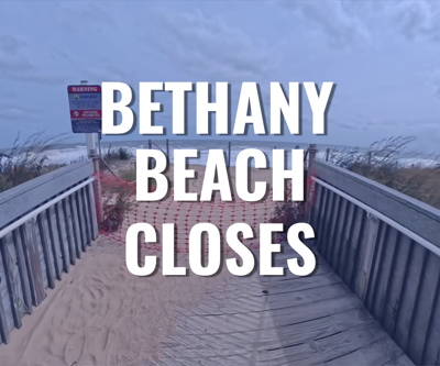 The walkway onto Bethany Beach with netting blocking the way with the text "bethany beach closes".