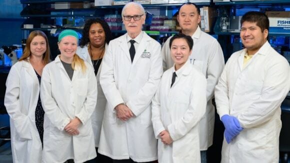 An image of the research team standing together in their white coats.