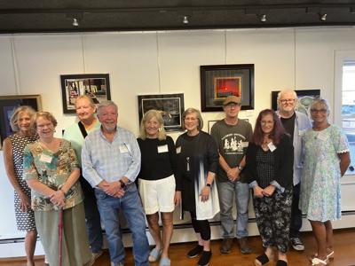 People line up in front of art in the gallery.