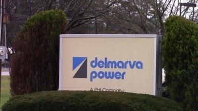 An exterior sign for Delmarva Power, surrounded by bushes.