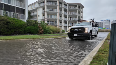 A truck driving through flooded side streets.