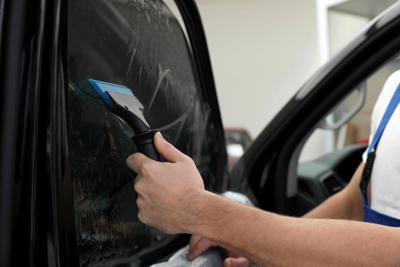 Tint being put on a car window.