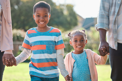 A family holds hands and smiles for a photo.