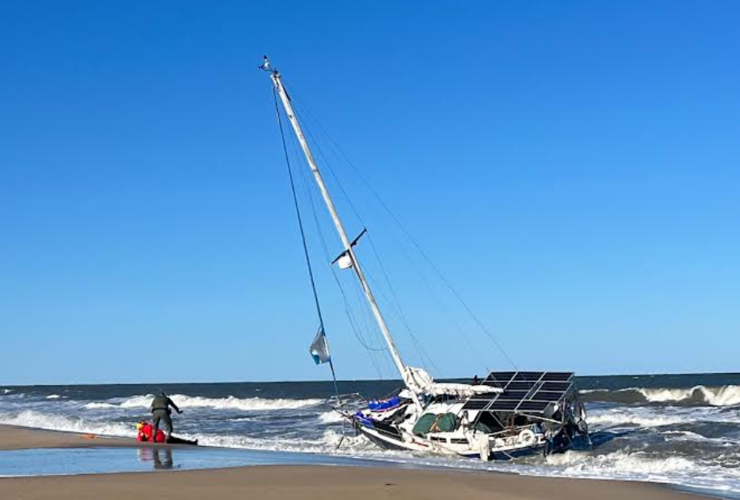officer helps sailor after boat comes ashore