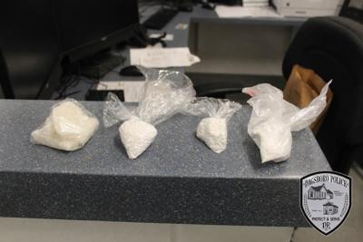 Four plastic bags of a white powder-like drug sit on a counter.