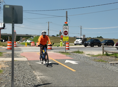 A biker on the path with construction behind him. 