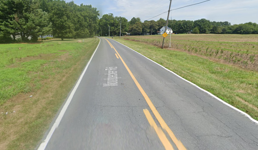 A road surrounded by trees and a field.