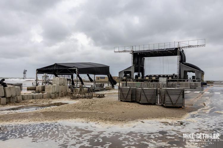 Water from the ocean creeps up on the equipment and stage for the Oceans Calling music festival on the beach.