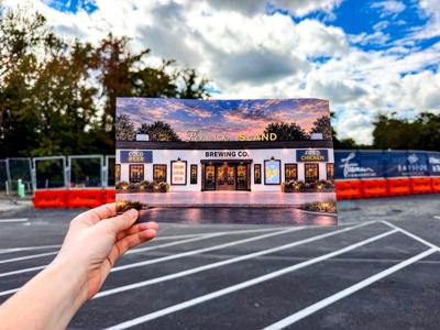 A picture of the finished construction in front of the current construction of the brewpub.