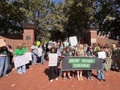 University of Delaware students holding their signs in support of survivors of sexual abuse.
