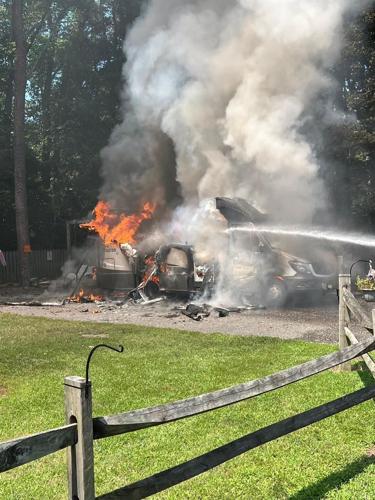Water being sprayed onto a recreational vehicle that is on fire.