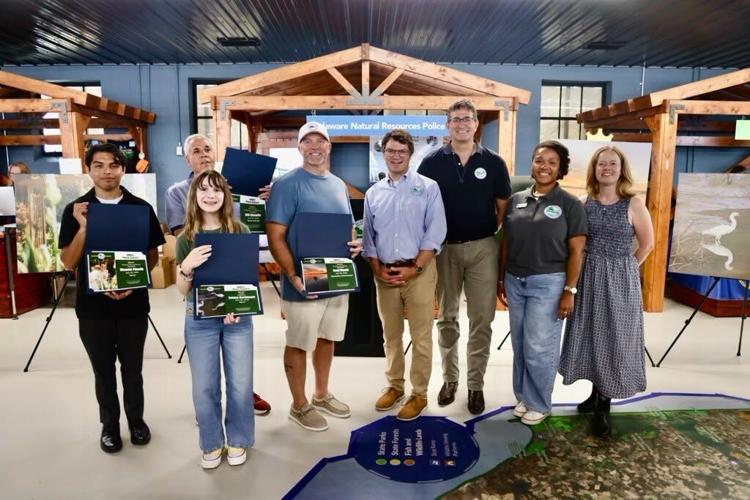 Delaware Governor Matt Meyer standing with the photo contest winners holding their certificates at the Delaware State Fair.