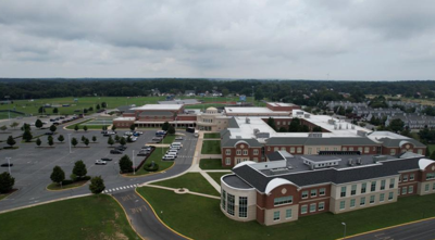 Cape Henlopen High School with the building on the right and parking lot on the right.