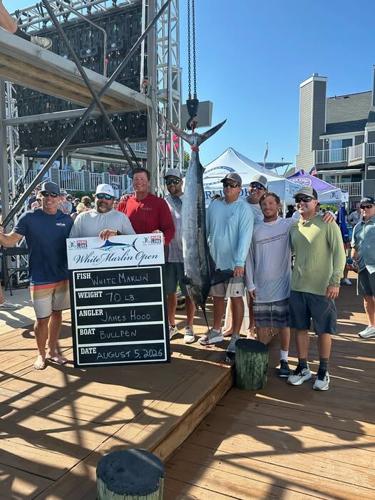 A group of men posing with their 70-pound white marlin at the scales.