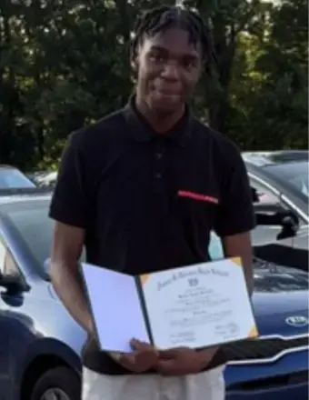 Tall young man holding a diploma.