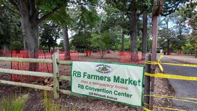 A sign indicating the Rehoboth Beach Farmers' Market has been temporarily moved to the Rehoboth Beach Convention Center.