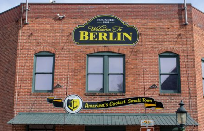The front of a brick building with a Berlin sign above three windows.