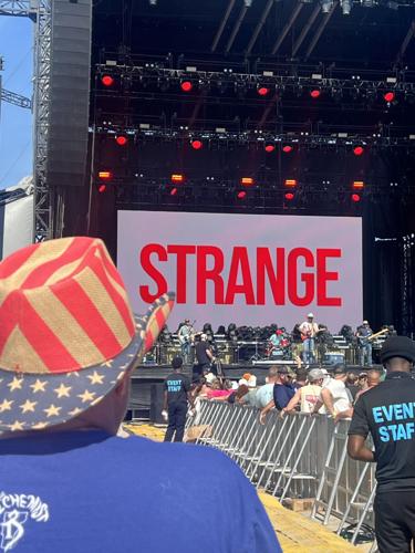 A man wearing an American flag cowboy hat watches the performance.