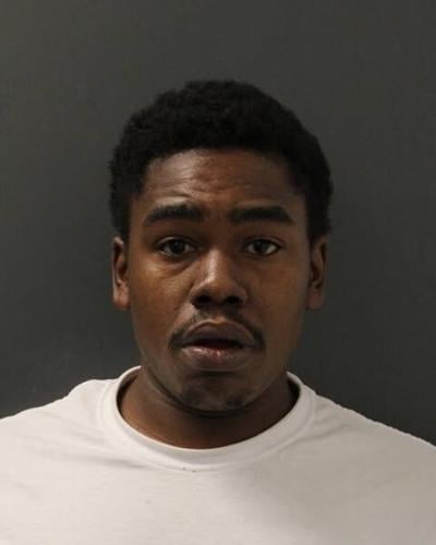 A mug shot of an African American man wearing a white t-shirt.