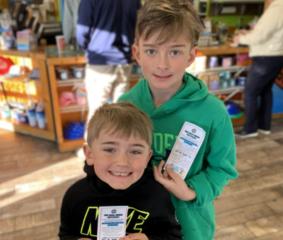 two students pose with a reward for a bagel and cream cheese