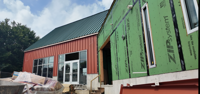 Partially completed building with red metal and green interior wall features. 