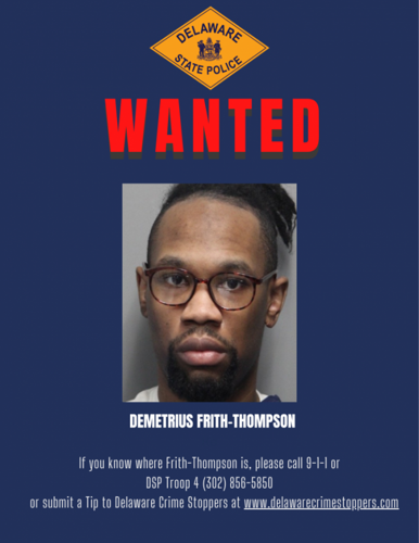 A wanted posted shows a man in glasses with his hair up.