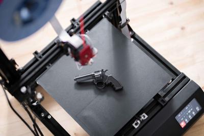 A gun being printed on a 3D printer.