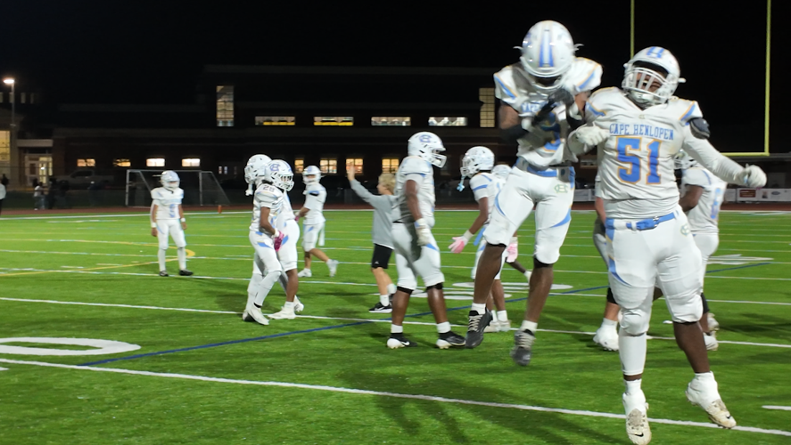 Football players jump in the air in celebration.