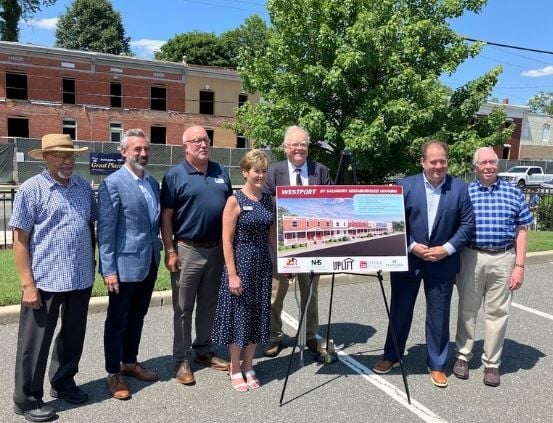 Salisbury and Maryland Housing leaders standing next to a mock-up of the redevelopment. 