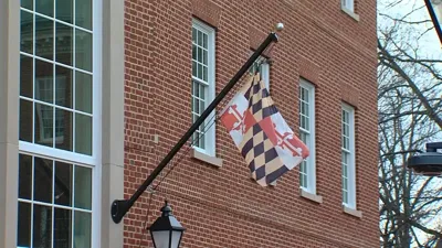Maryland flag flies outside building. 