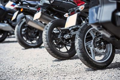 The back of four motorcycles on asphalt. 