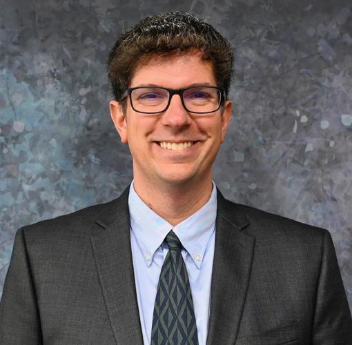 Historian Michael McKain poses for a photo, smiling. McKain is the social science department chair and collegewide coordinator for K-12 partnerships at Delaware Technical Community College in Georgetown. He previously taught middle and high school for 10 years.