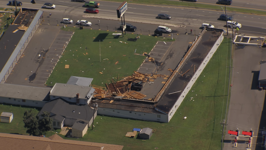 An aerial view of a roof destroyed, scattering wood.