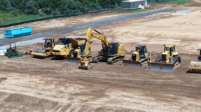 Yellow construction vehicles digging in dirt