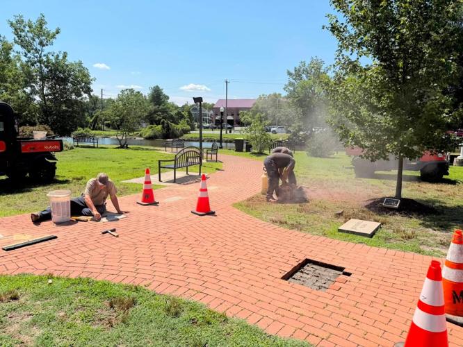 People working on the construction of a brick walkway.
