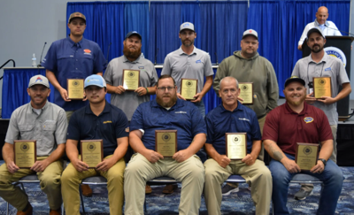 a group of men pose holding gold plaques 