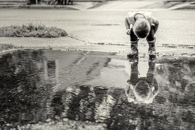 Huynh's daughter looking into puddle