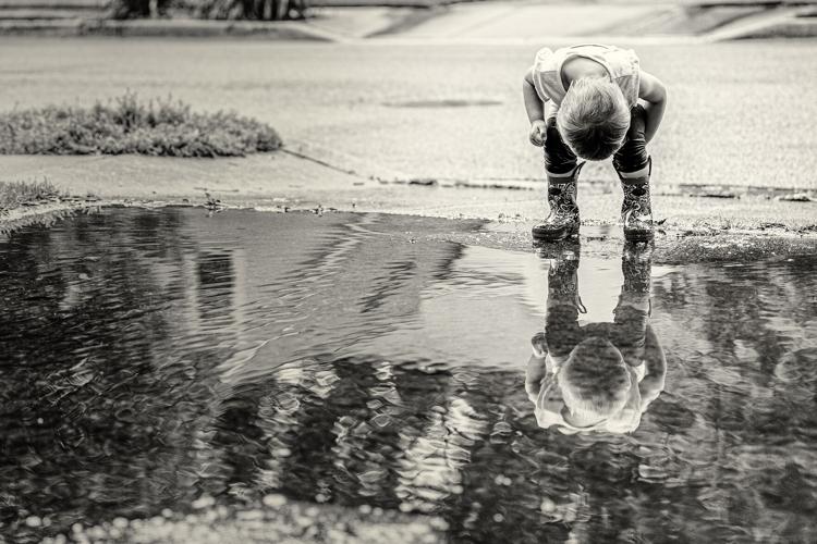 Huynh's daughter looking into puddle