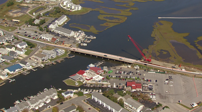 Route 54 Bridge is under construction, with drivers going over and a crane on the side of the road. 