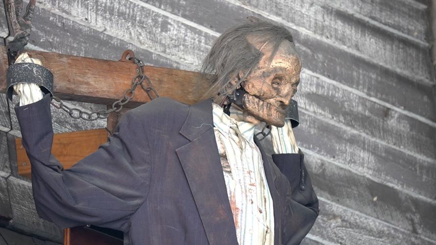 A skeleton on the wall looking down at the haunted mansion line
