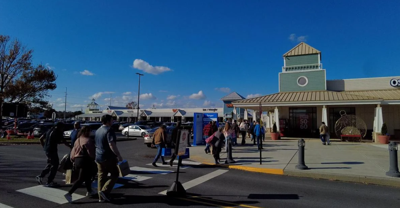 People cross a crosswalk to go to a store.